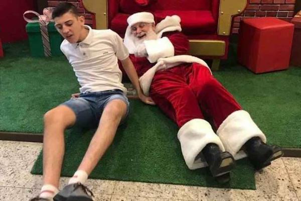 Papai Noel se joga no chão para atender menino autista e foto viraliza