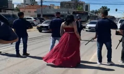 Homens armados param trânsito para 'dama de vermelho' atravessar rua e vídeo repercute nas redes sociais; ASSISTA